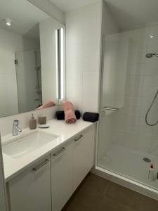 a white bathroom with a sink and a shower at Un havre de paix, face mer in Wimereux +33 photos