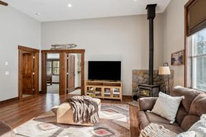 un soggiorno con divano e TV a schermo piatto di Secluded Mountain Retreat a Philipsburg