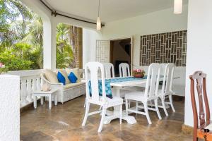 a porch with a white table and chairs at Bibi House Private Escape in Watamu