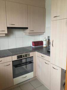 a kitchen with white cabinets and a stove top oven at Ferienhaus Edelweiss in Schüpfheim +7 photos