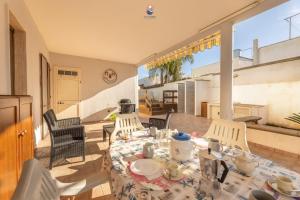ein Esszimmer mit einem Tisch und Stühlen sowie einem Balkon in der Unterkunft Villa La Palma By Vivimy in Taviano