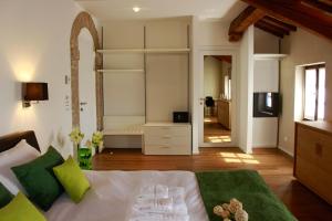 a bedroom with a bed with green pillows and a television at La Posa degli Agri in Legnaro