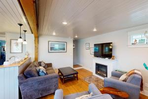 a living room with two couches and a fireplace at Rockaway Beach Bungalow in Rockaway Beach