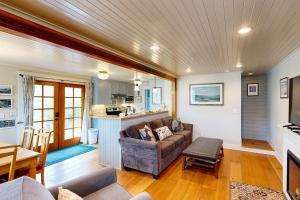 a living room with a couch and a kitchen at Rockaway Beach Bungalow in Rockaway Beach +10 photos
