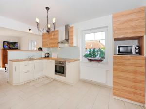 a kitchen with white cabinets and a window at Meine Kaptän-Kajüte in Neßmersiel