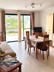 a living room with a table and chairs and a television at Mellieha Seaside Apartment in Mellieħa
