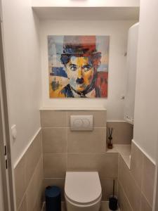 a bathroom with a painting of a man with a hat at le capitole in Fréjus