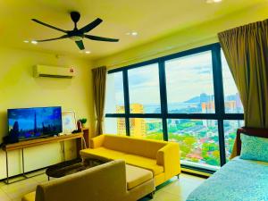 a living room with a yellow couch and a large window at Modern 2BR Home 5 Queen Beds, Near Attractions in Jelutong