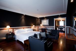 a bedroom with a white bed and two chairs at Hotel 1898 in Barcelona