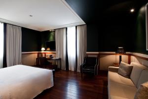 a hotel room with a bed and a couch at Hotel 1898 in Barcelona