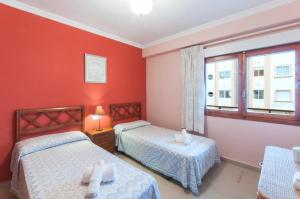 莫萊拉的住宿－Sirena，宿舍间的两张床,设有红色的墙壁和窗户。