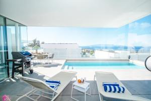カジャオ・サルバヘにあるLuxury Villa La Mia with heated poolのスイミングプール(椅子、テーブル付)