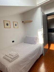a bedroom with a white bed with towels on it at Residenza Il Carducci in Bergamo