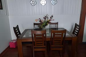 a dining room table with chairs and a vase of flowers at Casa Barrio estación in Temuco