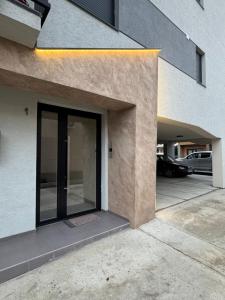 a door to a building with a parking lot at Niš East gate APT with balcony and free private Parking in Donja Vrežina