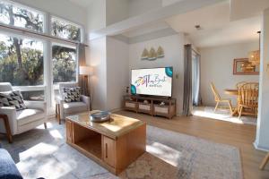 a living room with a tv and a table at Sea Cloud Retreat in Edisto Island