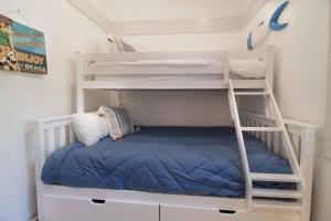 a white bunk bed with a blue blanket on it at Sea Cloud Retreat in Edisto Island