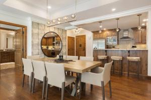 a kitchen and dining room with a wooden table and white chairs at Ritz Carlton Luxe 3 bed 4 bath in Vail