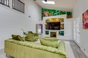 a living room with a green couch and a tv at Pop Art Oasis with Karaoke Mini Golf Hot Tub and Pool in Arvada