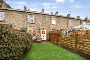 an exterior view of a brick house with a yard at Magpie Cottage - North East Escapes in Stanhope