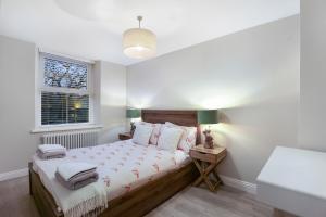 a bedroom with a bed and a window at Magpie Cottage - North East Escapes in Stanhope