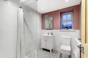 a bathroom with a toilet and a sink and a window at Magpie Cottage - North East Escapes in Stanhope +11 photos