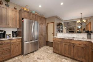 a kitchen with wooden cabinets and a stainless steel refrigerator at Stunning Mountain Retreat with View and Private Hot Tub in Tabernash