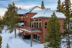 a large house with a deck in the snow at Stunning Mountain Retreat with View and Private Hot Tub in Tabernash