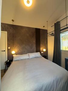 a bedroom with a large white bed with two lights at Casita con vistas a la montaña cerca de Murcia in Algezares