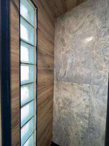 a bathroom with a stone wall and a window at Casita con vistas a la montaña cerca de Murcia in Algezares