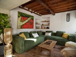a living room with a green couch and a table at MAS CANERS - 2 Eco-Chic Lodges, Nature Spa & Biological Pool in Montbolo