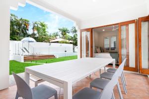 a white dining room with a white table and chairs at Casa Del Sol Palm Cove in Palm Cove