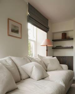 een witte bank in een kamer met een raam bij Old school - Charming Historic Cottage for Seven in Ballater +26 foto's