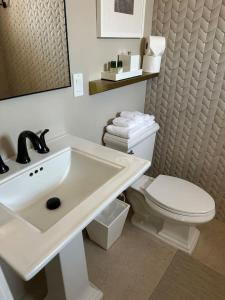 ein Badezimmer mit einem weißen Waschbecken und einer Toilette in der Unterkunft Palace Modern Residences at the Railyard - Studio in Santa Fe