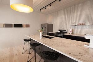 a kitchen with a counter with stools and a sink at Palace Modern Residences at the Railyard - 2 Bedroom Casa in Santa Fe