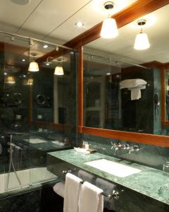 a bathroom with a sink and a large mirror at Hotel 1898 in Barcelona