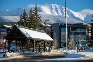 un edificio con cenador en la nieve con montañas en Trailside Mountain Retreat with Private Hot Tub, en Winter Park