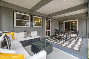Una sala de estar con un sofá blanco y una mesa. en TAL Getaway with POOL only 7 Mins to FSU, en Tallahassee