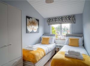 une chambre avec deux lits et une fenêtre dans l'établissement Nualas Lodge Private Hot Tub Escape, à Wilberfoss