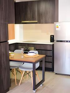a kitchen with a table and two chairs and a refrigerator at Tranquilo Departamento Frente al Movistar Arena in Santiago