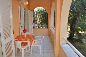 a balcony with a table and chairs and a window at Egli Apartments in Kontokali