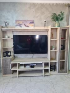 a entertainment center with a flat screen tv at Apartment in Flic en Flac of 68 m² with pool in Flic-en-Flac