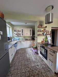 a kitchen with white cabinets and a tile floor at 3 room apartment with castle view in Trenčín +7 photos