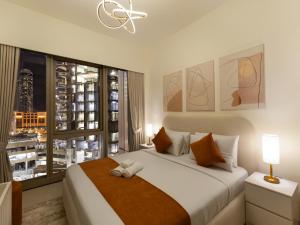 a bedroom with a large bed and a window at Elegant 1BR I 1min walk to Burj Khalifa & Fountain in Dubai +43 photos