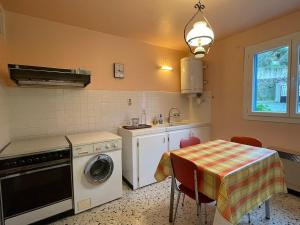 een keuken met een tafel en een wasmachine bij Casa Nunziada in Patrimonio Garden level, Quiet and Bright in Patrimonio