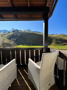 a porch with a wicker chair and a view of a hill at Traumurlaub in Sicht! 77qm Familiendomizil in Münstertal
