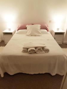 Una cama blanca grande con dos toallas encima. en Gîte de France Aux deux mésanges 4 épis - Gîte de France 10 personnes MAE-6364, en Sainte-Fortunade