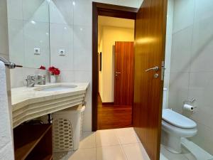 een badkamer met een wastafel en een toilet. bij Madeira Emotions Apartments in Funchal +21 foto's