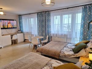 a bedroom with two beds and a table and chairs at Willa Turnia Karpacz in Karpacz
