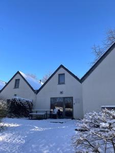 a white building with snow on the ground at Le havre du lac in Vielsalm
